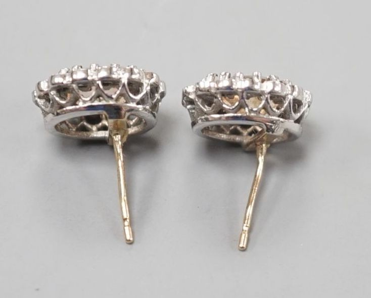 A pair of modern 9ct gold, topaz and diamond set oval cluster earrings, 11mm, gross weight 2.8 grams.